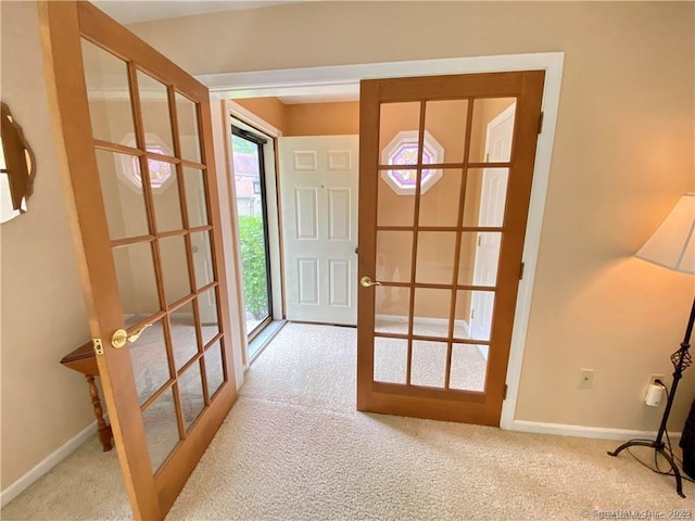 doorway featuring carpet flooring and baseboards