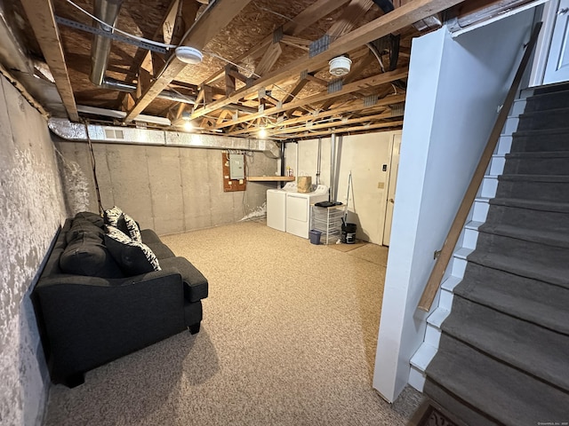 unfinished below grade area featuring separate washer and dryer, carpet floors, stairs, and electric panel
