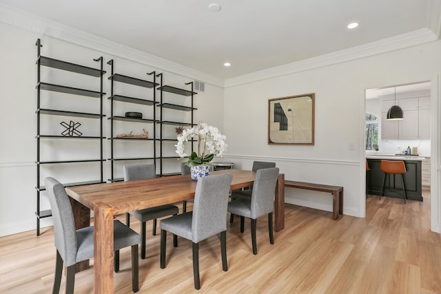 dining room featuring baseboards, ornamental molding, light wood-style floors, and recessed lighting
