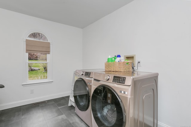 washroom with washing machine and dryer, baseboards, laundry area, and visible vents
