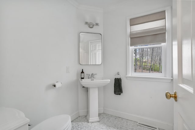 bathroom with visible vents, toilet, ornamental molding, a sink, and baseboards