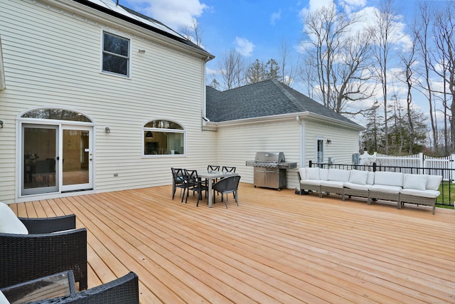 wooden terrace with fence, outdoor dining area, a grill, and an outdoor living space