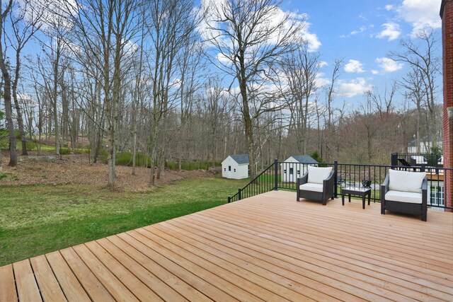 deck featuring a storage shed, an outbuilding, and a lawn