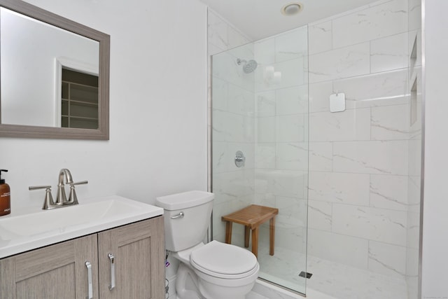 full bathroom with tiled shower, vanity, and toilet
