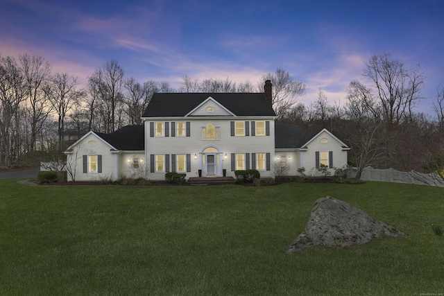 view of front of home featuring a chimney and a front lawn