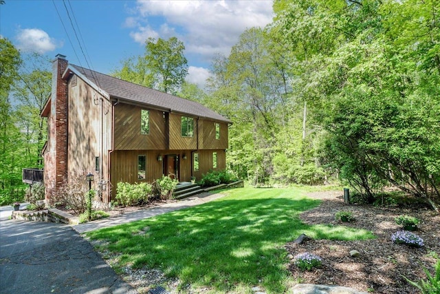 view of front of home featuring a chimney and a front lawn