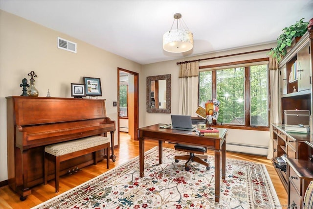 home office featuring a baseboard radiator and light wood-type flooring