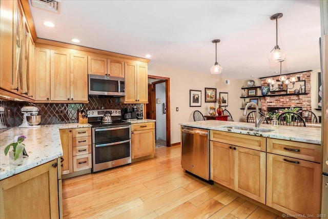 kitchen featuring stainless steel appliances, a sink, tasteful backsplash, pendant lighting, and light brown cabinets