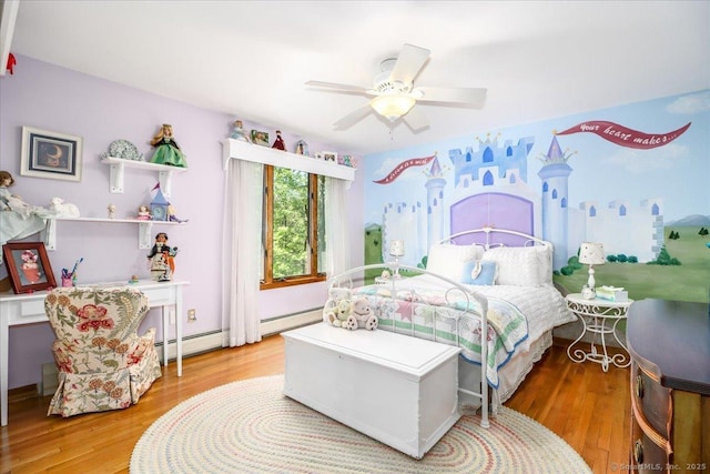 bedroom with wood finished floors, baseboard heating, and a ceiling fan
