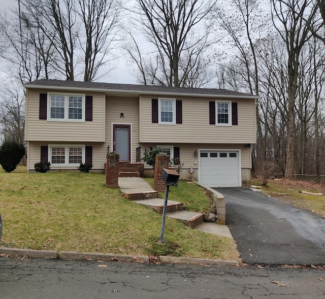 bi-level home featuring aphalt driveway, a front yard, and a garage