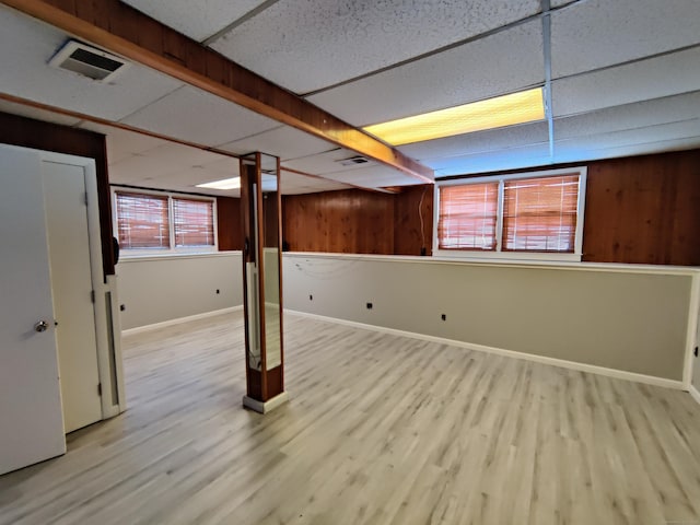 below grade area featuring wood finished floors, visible vents, wood walls, and a paneled ceiling