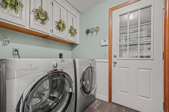laundry room with cabinet space, wainscoting, and washing machine and dryer