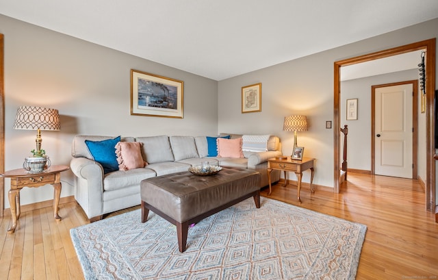 living room with baseboards and light wood-style flooring