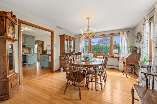 dining area with light wood-type flooring, a baseboard heating unit, and a notable chandelier