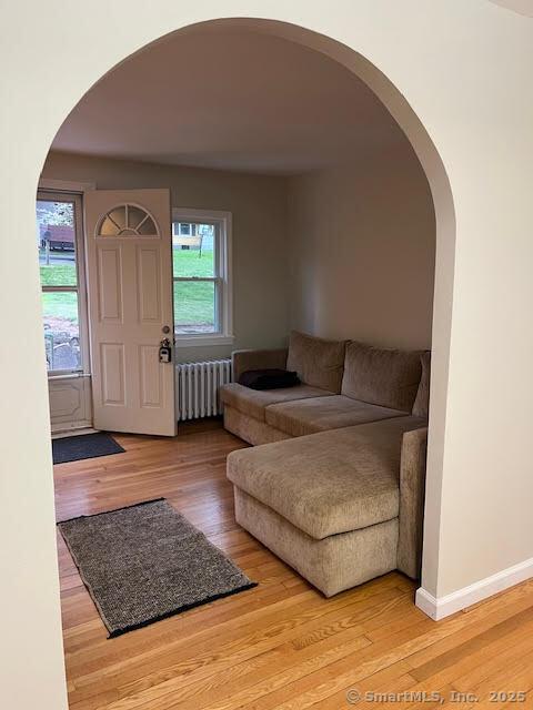 12 Homecrest St, Newington, CT 06111 - foyer entrance with radiator heating unit, light wood-style floors, arched walkways, and baseboards