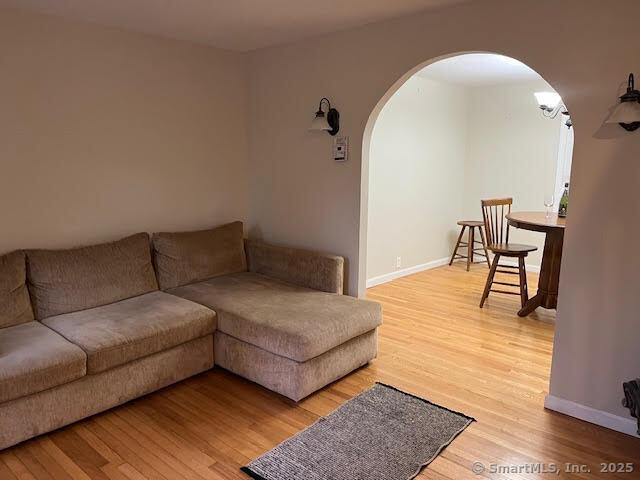 12 Homecrest St, Newington, CT 06111 - living area with arched walkways, wood finished floors, and baseboards
