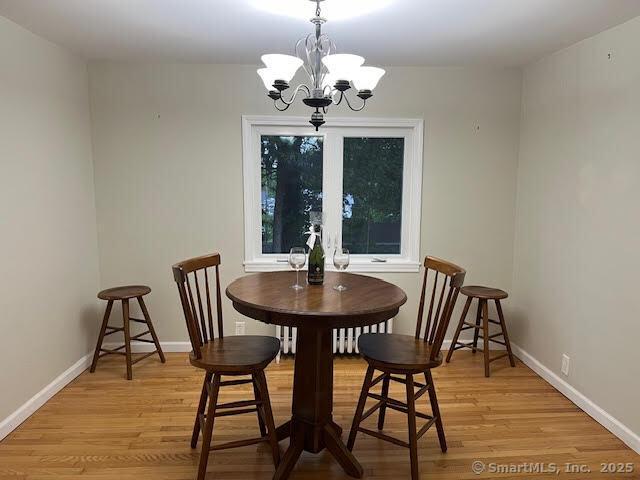 12 Homecrest St, Newington, CT 06111 - dining area featuring a chandelier, light wood-type flooring, and baseboards