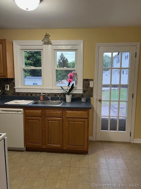 12 Homecrest St, Newington, CT 06111 - kitchen with white dishwasher, dark countertops, a sink, and plenty of natural light