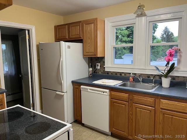 12 Homecrest St, Newington, CT 06111 - kitchen featuring white appliances, dark countertops, a sink, tasteful backsplash, and brown cabinets