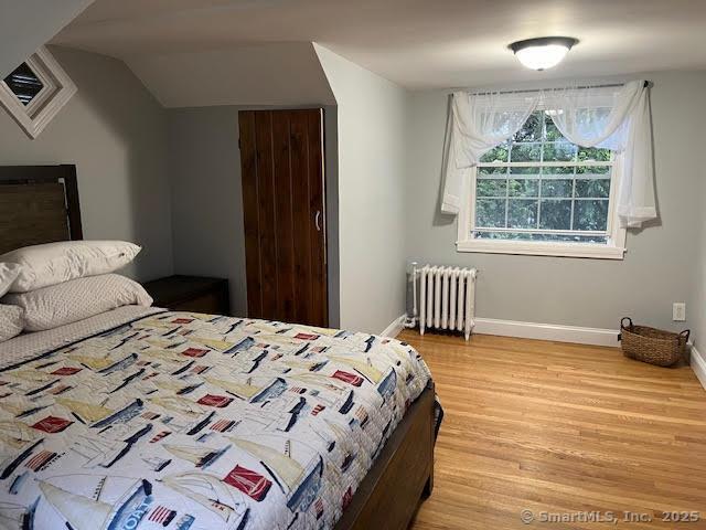 12 Homecrest St, Newington, CT 06111 - bedroom featuring radiator heating unit, light wood finished floors, baseboards, and lofted ceiling