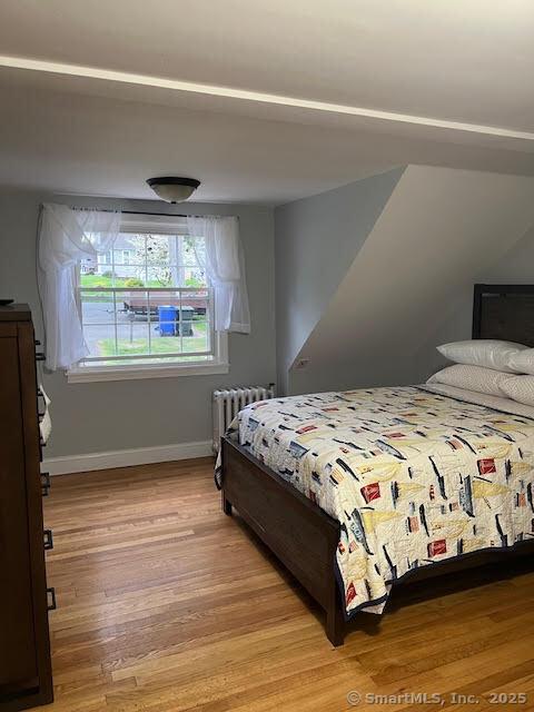 12 Homecrest St, Newington, CT 06111 - bedroom featuring radiator heating unit, light wood-type flooring, and baseboards