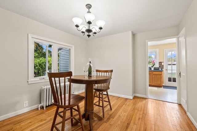 12 Homecrest St, Newington, CT 06111 - dining space with radiator heating unit, a chandelier, and light wood finished floors