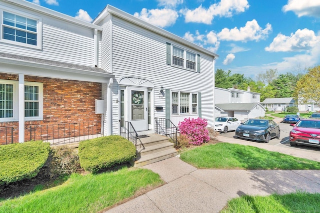 view of front of home featuring brick siding and uncovered parking