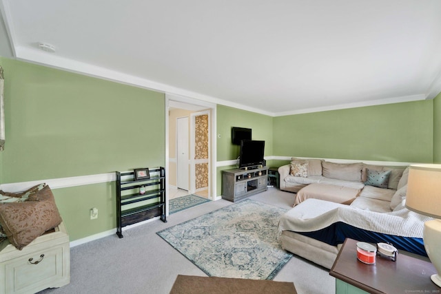 living room featuring baseboards, ornamental molding, and carpet