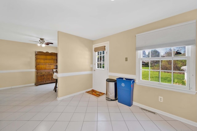 unfurnished room featuring visible vents, baseboards, ceiling fan, and a healthy amount of sunlight