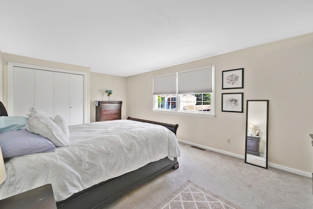 bedroom with baseboards, carpet, a closet, and visible vents