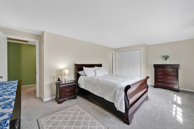 bedroom featuring baseboards, a closet, and light carpet