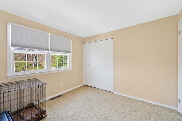 bedroom with baseboards, visible vents, carpet, and a closet