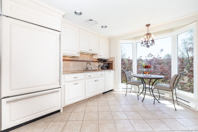 kitchen featuring a sink, decorative backsplash, light tile patterned flooring, a notable chandelier, and visible vents