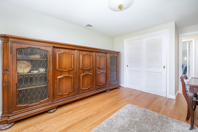 foyer entrance featuring visible vents, light wood-style flooring, and baseboards