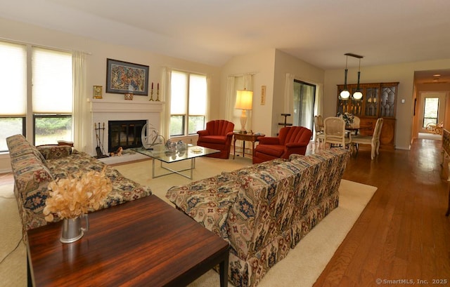 living room with a glass covered fireplace and wood finished floors