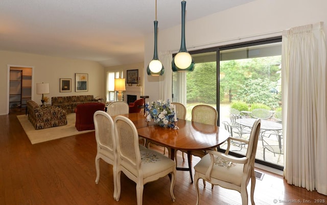 dining space featuring wood finished floors and a fireplace