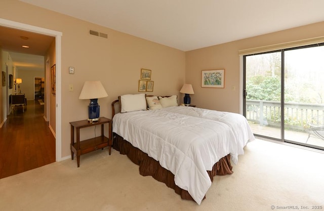 carpeted bedroom with baseboards, access to exterior, and visible vents