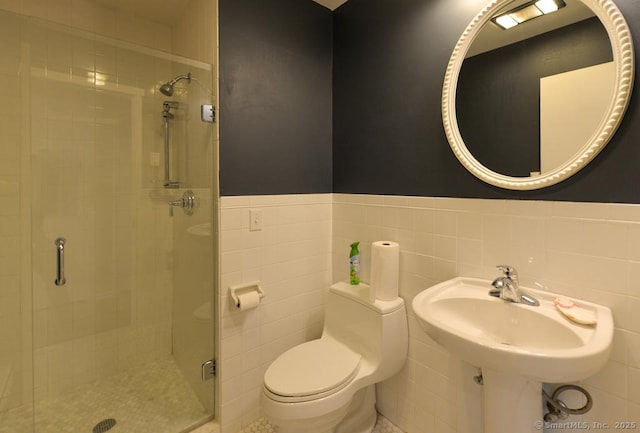 full bath featuring tile walls, toilet, a wainscoted wall, and a stall shower