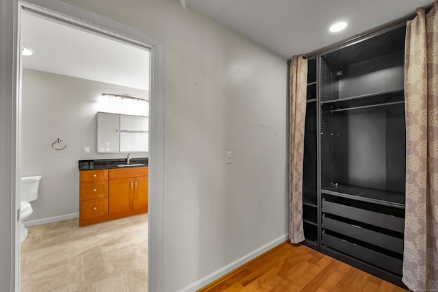interior space featuring a sink, baseboards, and recessed lighting
