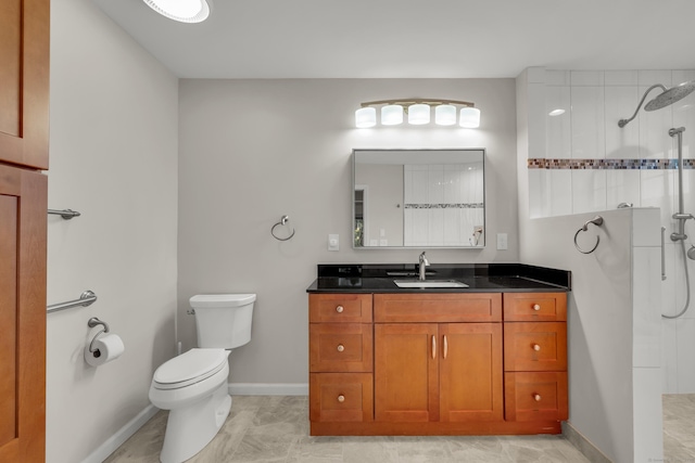 bathroom featuring baseboards, vanity, toilet, and tiled shower