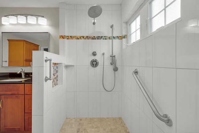 full bathroom with tiled shower and vanity