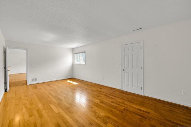 12 Southbridge Ct Unit 12, Simsbury, CT 06070 - spare room featuring light wood-style flooring, baseboards, and a textured ceiling