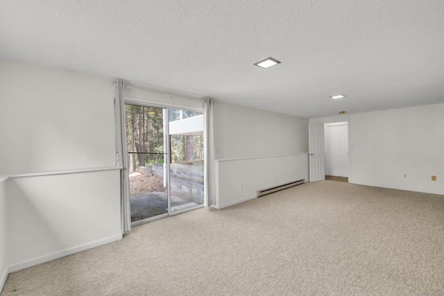 carpeted empty room featuring a textured ceiling and baseboard heating