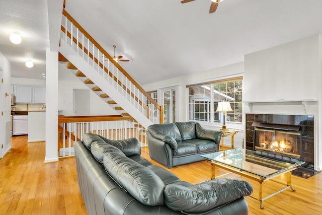 12 Southbridge Ct Unit 12, Simsbury, CT 06070 - living room featuring ceiling fan, light wood-type flooring, a tiled fireplace, and stairs