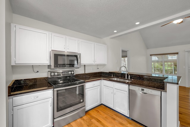 12 Southbridge Ct Unit 12, Simsbury, CT 06070 - kitchen with stainless steel appliances, a sink, a peninsula, light wood-style floors, and vaulted ceiling
