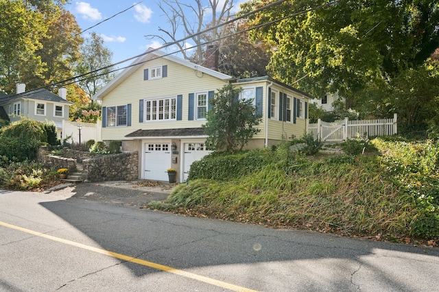 view of front of house with a garage and fence