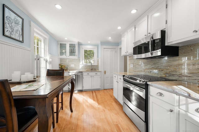 kitchen with plenty of natural light, white cabinetry, and appliances with stainless steel finishes