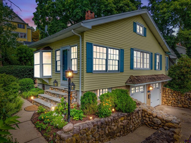 16 N Main St, Essex, CT 06426 - view of property exterior with a chimney, concrete driveway, a garage, and entry steps