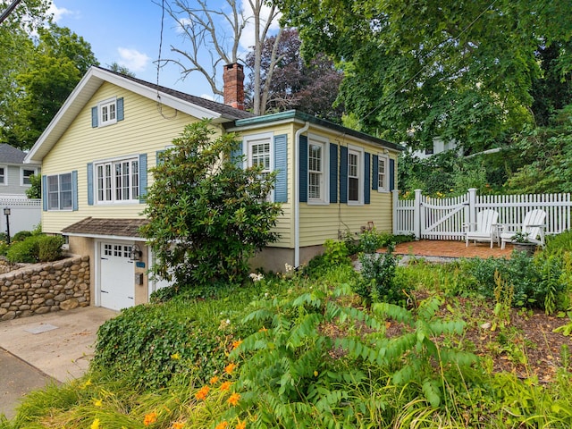 16 N Main St, Essex, CT 06426 - view of side of home featuring a chimney, a garage, and concrete driveway