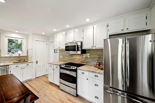 16 N Main St, Essex, CT 06426 - kitchen featuring appliances with stainless steel finishes, tasteful backsplash, white cabinets, light wood finished floors, and recessed lighting